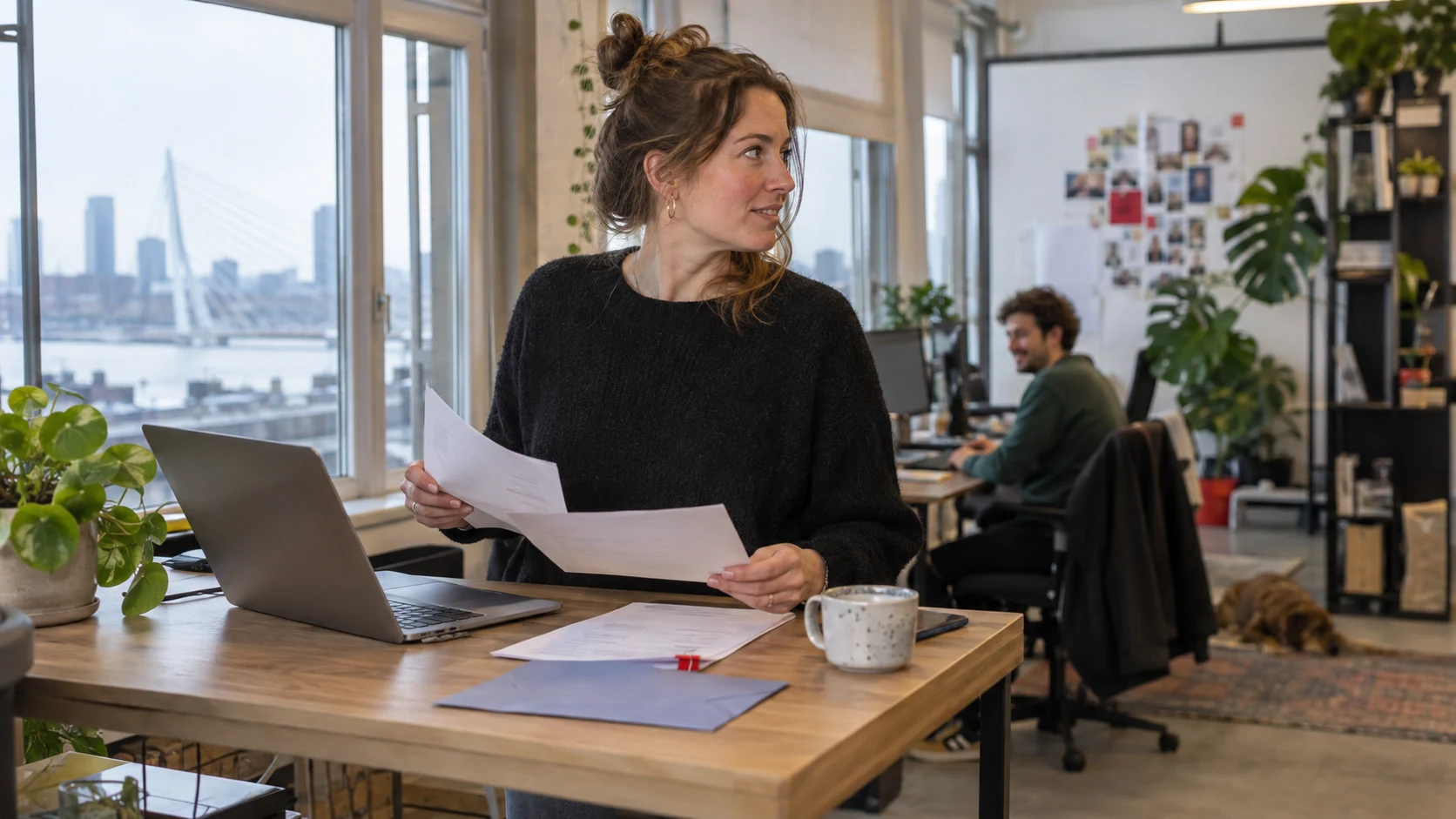 Ondernemer vergelijkt beleggingspapieren bij haar laptop.