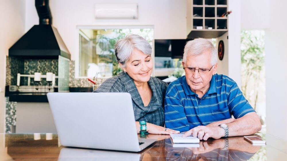 A man sitting at a table using a laptop