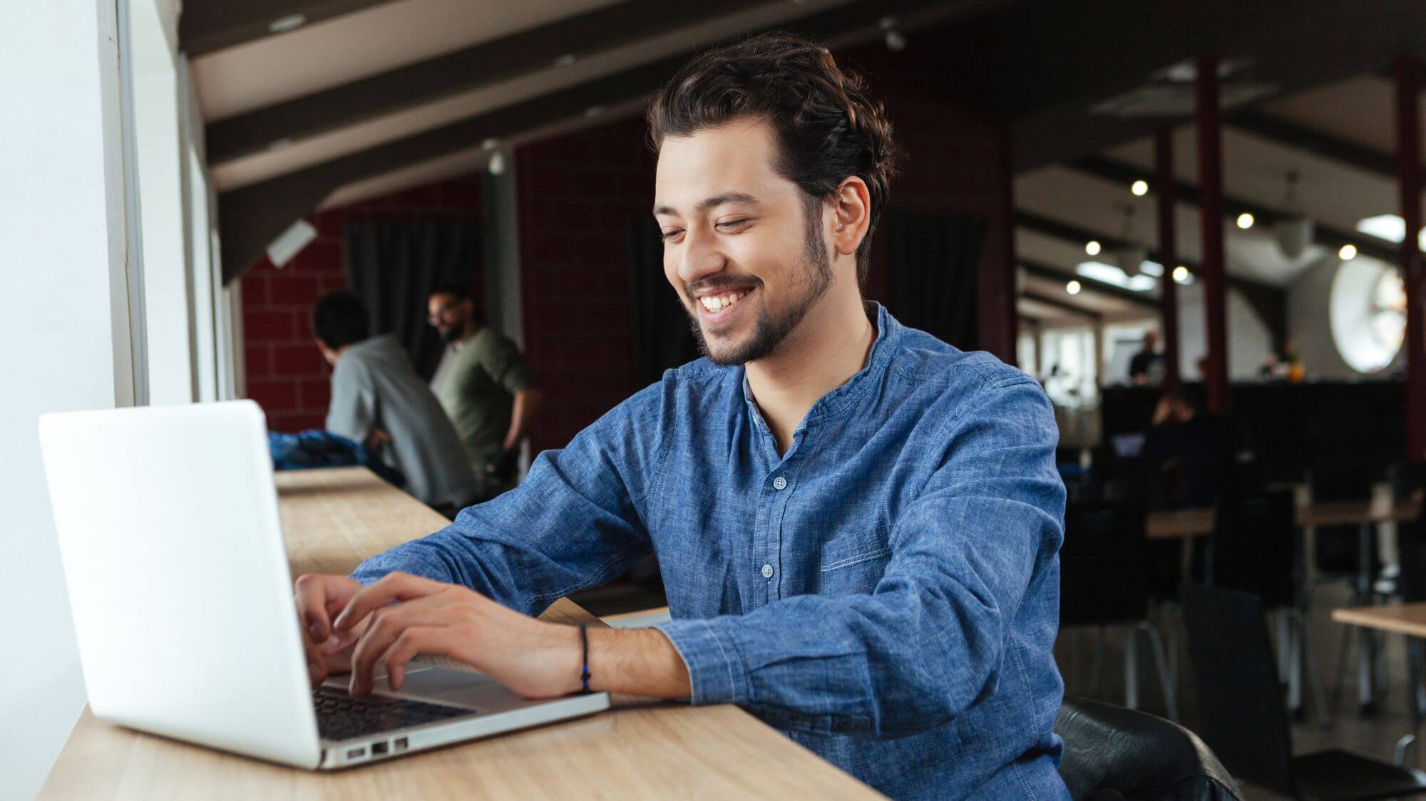A man sitting at a table using a laptop