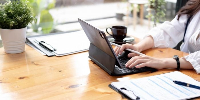 A person sitting at a table using a laptop